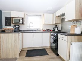 A kitchen with a stove and microwave at Number 34 Foxburrow Hang in Great Yarmouth