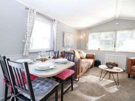 A living room with a dining area and seating at Number 34 Foxburrow Hang in Great Yarmouth