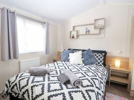 A bedroom with a bed and shelves at Number 34 Foxburrow Hang in Great Yarmouth