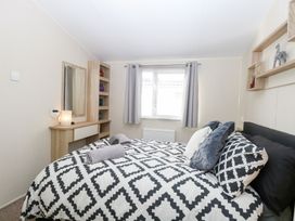 A bedroom with a bed and shelf at Number 34 Foxburrow Hang in Great Yarmouth