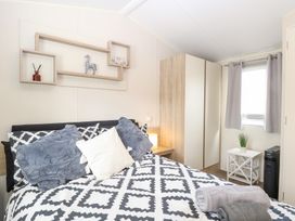 A bedroom with a bed and wardrobe at Number 34 Foxburrow Hang Great Yarmouth