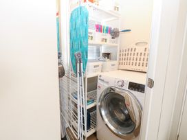 A laundry room with a washing machine and ironing board at Number 34 Foxburrow Hang, Great Yarmouth