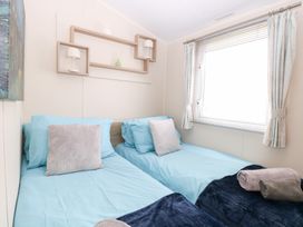 A bedroom with two beds and a window at Number 34 Foxburrow Hang in Great Yarmouth