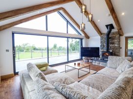 A living room with a sofa and television at Perth Y Deri in Llanddwywe