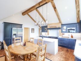 A kitchen with a dining table and appliances at Perth Y Deri in Llanddwywe