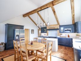 A kitchen with a dining table and chairs at Perth Y Deri in Llanddwywe