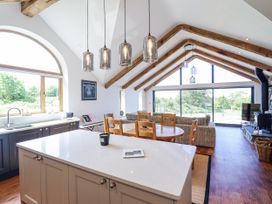 A kitchen with dining area and large windows at Perth Y Deri in Llanddwywe