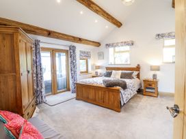 A bedroom with a bed and wardrobe at Perth Y Deri in Llanddwywe