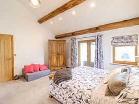 A bedroom with a bed and wardrobe at Perth Y Deri in Llanddwywe