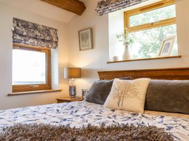 A bedroom with a bed and windows at Perth Y Deri Llanddwywe