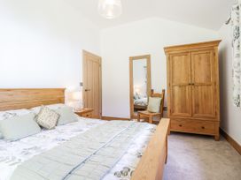 A bedroom with a bed and wardrobe at Perth Y Deri in Llanddwywe