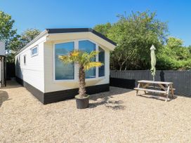 A caravan with a palm tree and picnic table at White Hart Caravan in Battle