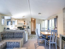 A living room with a sofa and dining area at White Hart Caravan in Battle