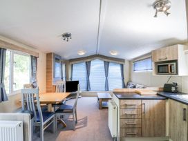 A living room with a dining table and chairs at White Hart Caravan in Battle