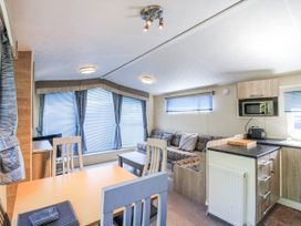 A living room with a sofa and table at White Hart Caravan in Battle