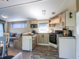 A kitchen with appliances and seating area at White Hart Caravan in Battle