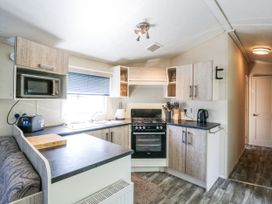 A kitchen with appliances and cabinets at White Hart Caravan in Battle