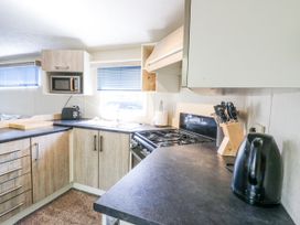 A kitchen with appliances and counter space at White Hart Caravan in Battle