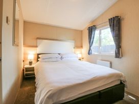 A bedroom with a bed and window at White Hart Caravan in Battle
