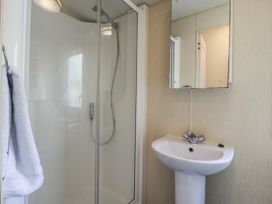 A bathroom with a shower and sink at White Hart Caravan in Battle