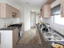 A kitchen with cabinets and a sink at Nature's Nook - Billing Aquadrome
