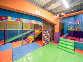 An indoor children's play area with soft padded flooring climbing structures and colorful walls at Meadowview - Billing Aquadrome in Billing Aquadrome Holiday Park