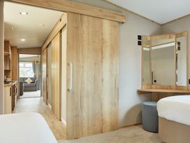 A bedroom with a mirror and sofa at Meadowview - Billing Aquadrome