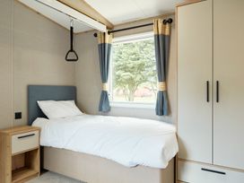 A bedroom with a bed and a window at Meadowview - Billing Aquadrome