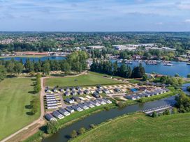 An aerial view of a holiday park with rows of caravans near a river and a marina with boats in Billing Aquadrome Holiday Park