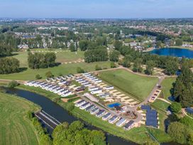 An aerial view of a holiday park with rows of cabins along a river and large green fields at Billing Aquadrome Holiday Park