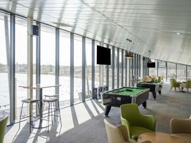 A leisure room with pool tables chairs and large windows overlooking water at Willowbrook Hideaway - Billing Aquadrome in Billing Aquadrome Holiday Park