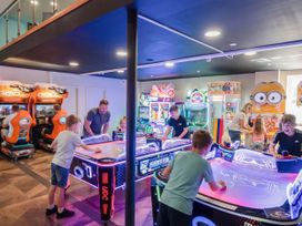 A game room with arcade machines and air hockey tables at Willowbrook Hideaway - Billing Aquadrome