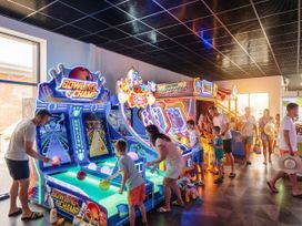 A game room with bowling and arcade machines at Brookside Bliss - Billing Aquadrome