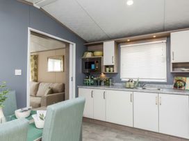 A kitchen with cabinets and appliances at Sandy Shores - Hayling Island