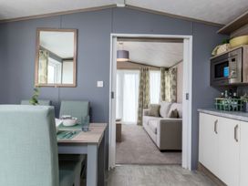 A dining area with a table and chairs at Sandy Shores - Hayling Island