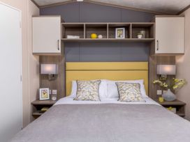 A bedroom with a bed and nightstand at Sandy Shores - Hayling Island