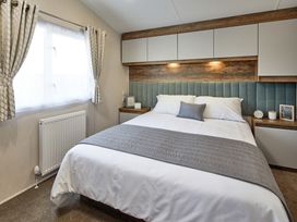 A bedroom with a bed and bedside table at Island Breeze - Hayling Island