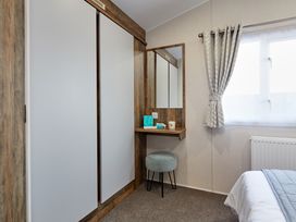 A bedroom with a vanity table and mirror at Island Breeze - Hayling Island