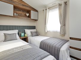 A bedroom with two beds and a window at Island Breeze - Hayling Island