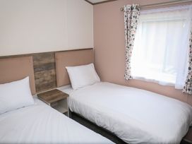 A bedroom with two beds and a window at Harbour Haven - Hayling Island