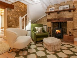 A living room with a fireplace and seating at The Cottage in Stow-On-The-Wold