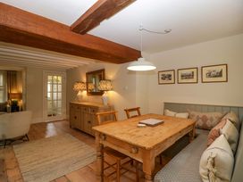 A dining room with a wooden table and chairs at The Cottage in Stow-On-The-Wold
