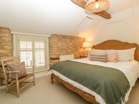 A bedroom with a bed and chair at The Cottage Stow-On-The-Wold