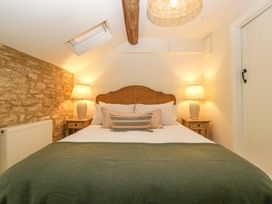 A bedroom with a bed, nightstands, and lamps at The Cottage in Stow-On-The-Wold