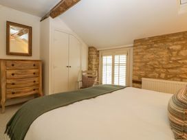 A bedroom with a bed and wooden furniture at The Cottage in Stow-On-The-Wold