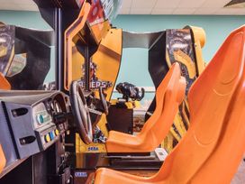 An arcade machine with a steering wheel and seat at Golden Dune - Hayling Island