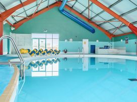 An indoor pool with a ladder and a reception area at Golden Dune - Hayling Island
