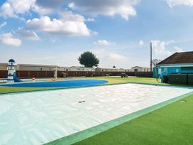 An outdoor play area with a swimming pool and lighthouse structure at Golden Dune - Hayling Island