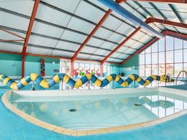 An indoor swimming pool with a blue and yellow snake-shaped pool divider at Beachcomber's Base - Hayling Island in Hayling Island Holiday Park