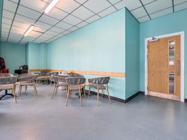 A room with blue walls wooden door several tables and chairs at Beachcomber's Base - Hayling Island in Hayling Island Holiday Park
